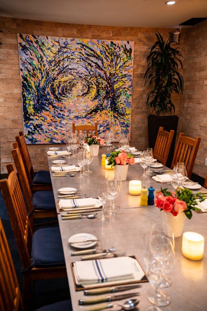 Dining table with place settings and artwork on the wall