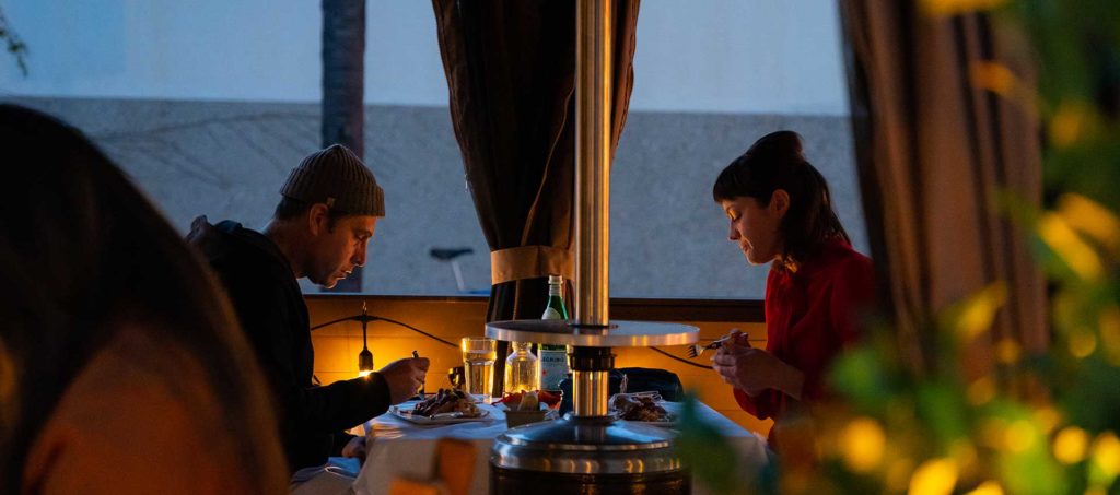 A couple sitting at a table on the bouchon terrace.