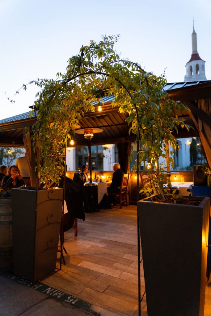 A couple sitting at a table on the bouchon terrace in the evening.